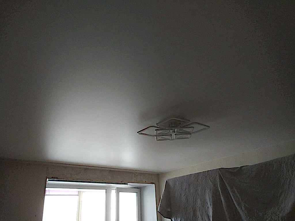 Сатиновый натяжной потолок в гостинной 17,25 кв.м. с люстрой