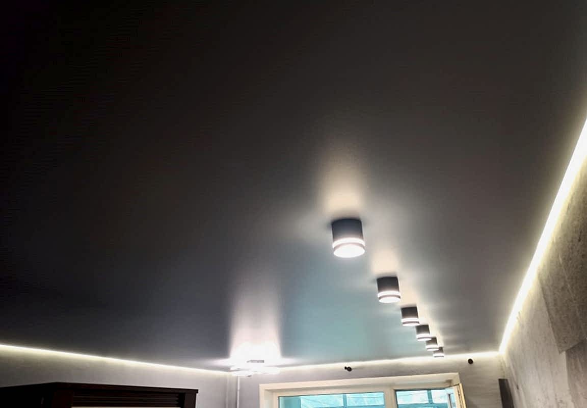 Светильники стаканчики и люстра в глянцевом натяжном потолке с подсветкой