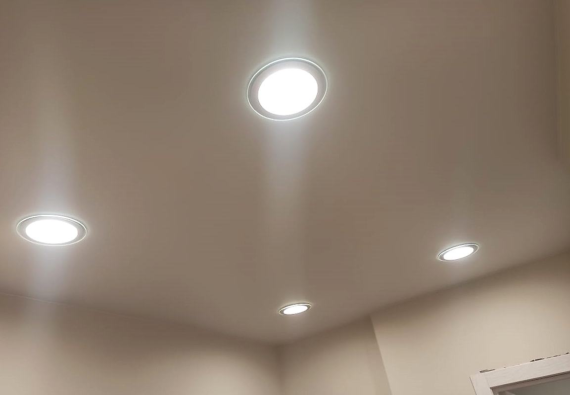 Матовый натяжной потолок и встроенные точечные светильники в кухне.