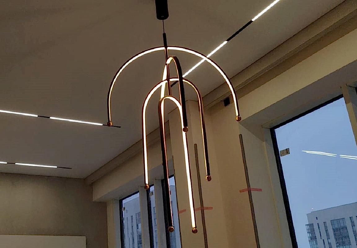 Натяжной потолок со встроенной трековой системой и люстрой.