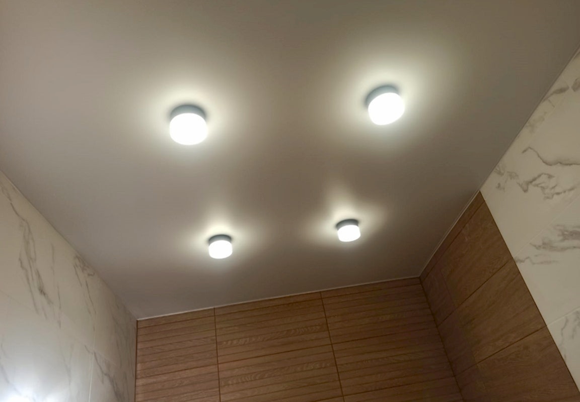 Светильники стаканчики в матовом натяжном потолке в ванной.