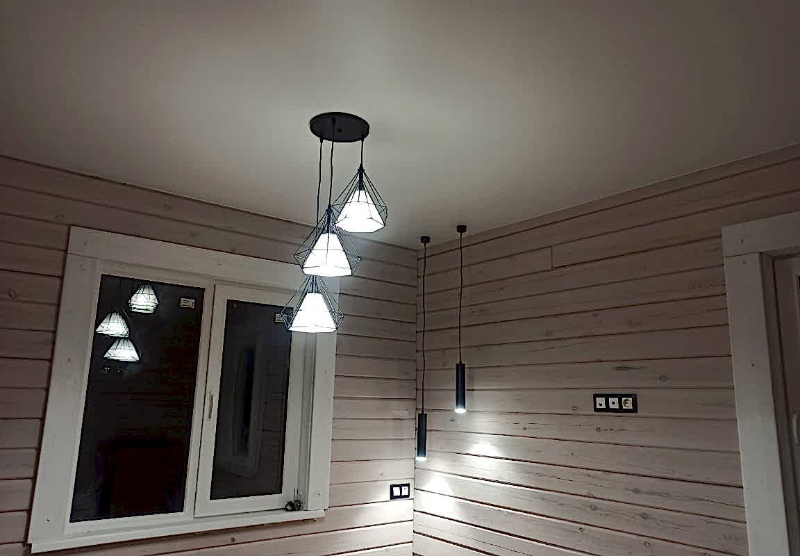 Светильники на подвесах ,натяжной потолок в интерьере гостиной 23,5 кв.м.