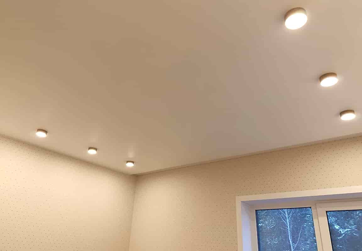 Светильники и встроенная в потолок гардина в натяжном потолке в спальне.