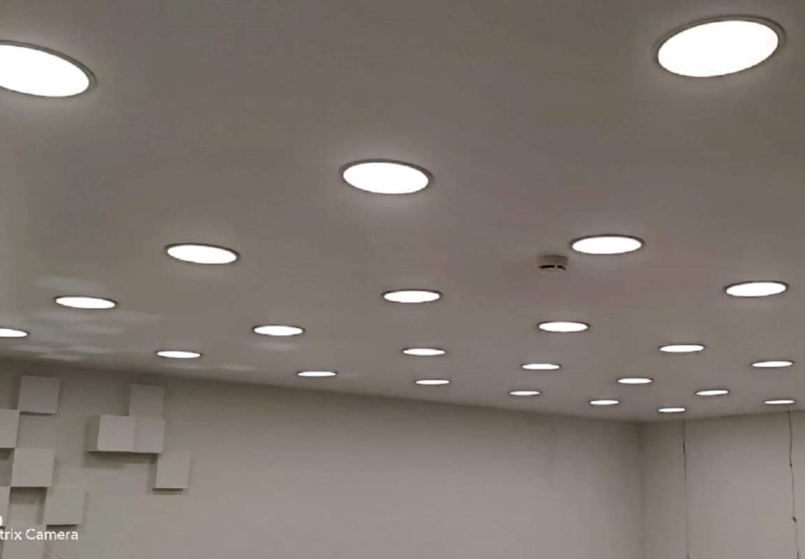 Интерьер офиса с матовым натяжным потолком и точечными светильниками.