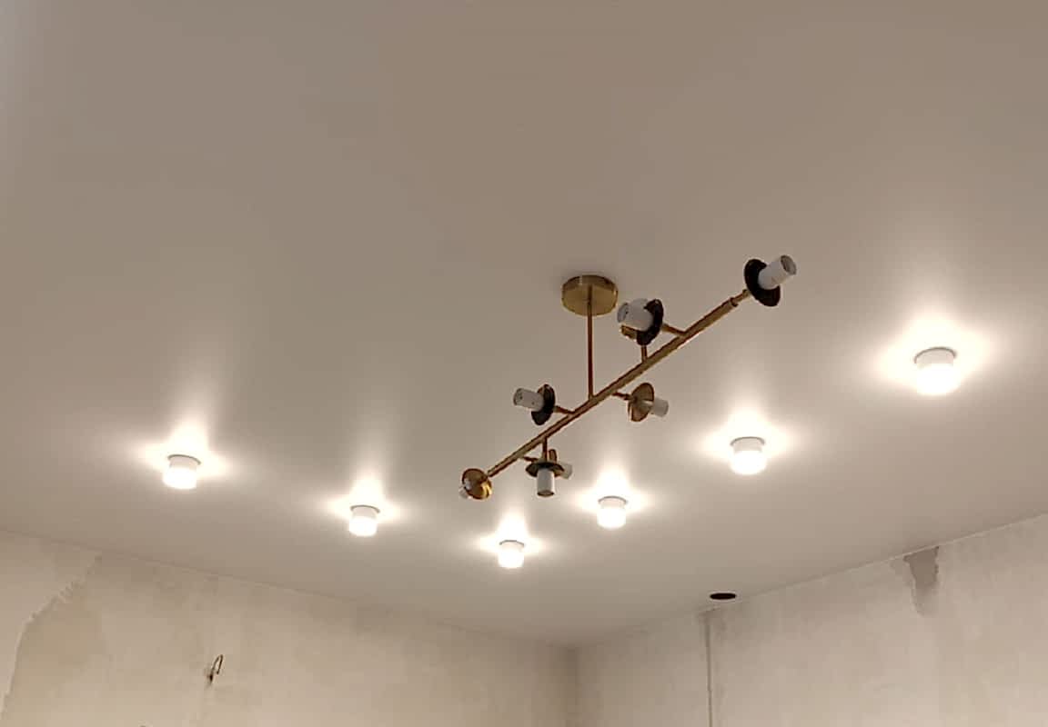 Матовый натяжной потолок, накладные светильники в интерьере кухни.