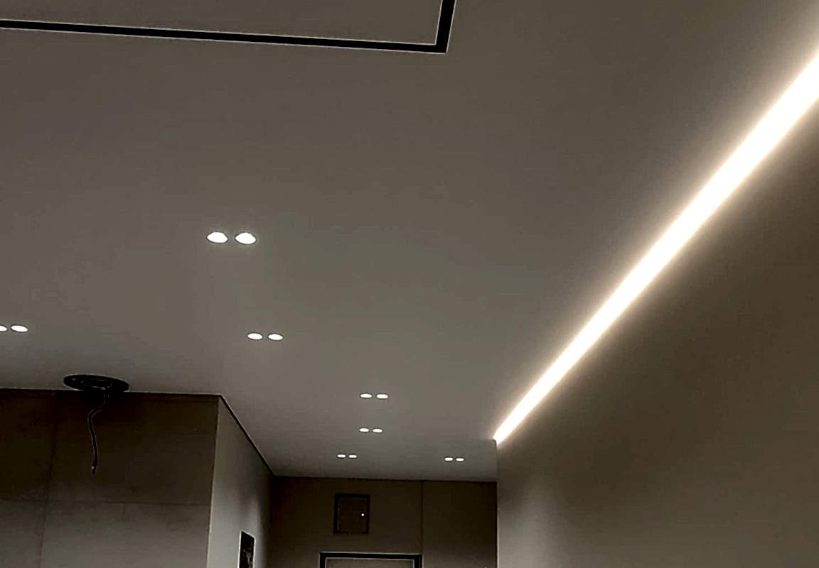 Сатиновые натяжные потолки,акцентная подсветка и встроенный трековый светильник в интерьере.