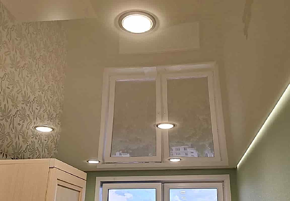 Точечные светильники и глянцевый цветной натяжной потолок в спальне.