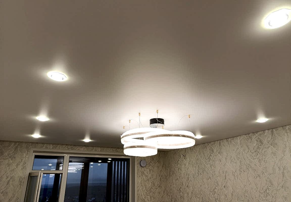 Сатиновое полотно натяжного потолка,люстра ,светодиодная люстра на подвесах в гостиной 16,8 кв.м.